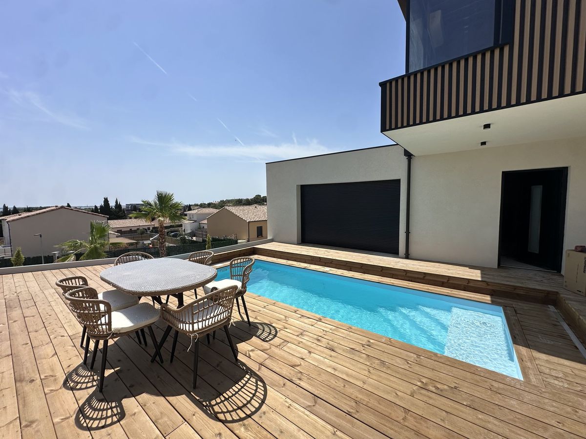 Ensemble terrasse en bois et piscine chauffée de la villa container